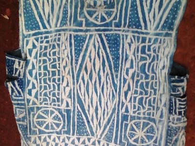 Le ndop, connu comme un tissu sacré et royal, appartient aux peuples Bamiléké et Bamoun dans la région de l’ouest du Cameroun. Il se confectionne grâce à la trinité végétale : coton – indigo – raphia.
