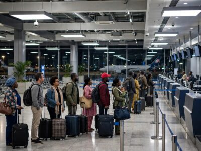 Passagers faisant la queue au comptoir d'enregistrement à l'aéroport de Yaoundé-Nsimalen pour un vol du soir