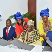 Signature de l'accord tripartite World Dream Investment Ndolle City à l'hôtel Hilton de Yaoundé en août 2025, avec Hamish Ellis Jack à droite et un chef traditionnel camerounais au centre