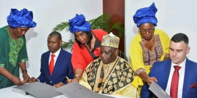 Signature de l'accord tripartite World Dream Investment Ndolle City à l'hôtel Hilton de Yaoundé en août 2025, avec Hamish Ellis Jack à droite et un chef traditionnel camerounais au centre